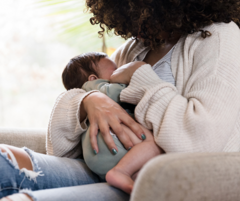 A mother holding a baby close to her chest.